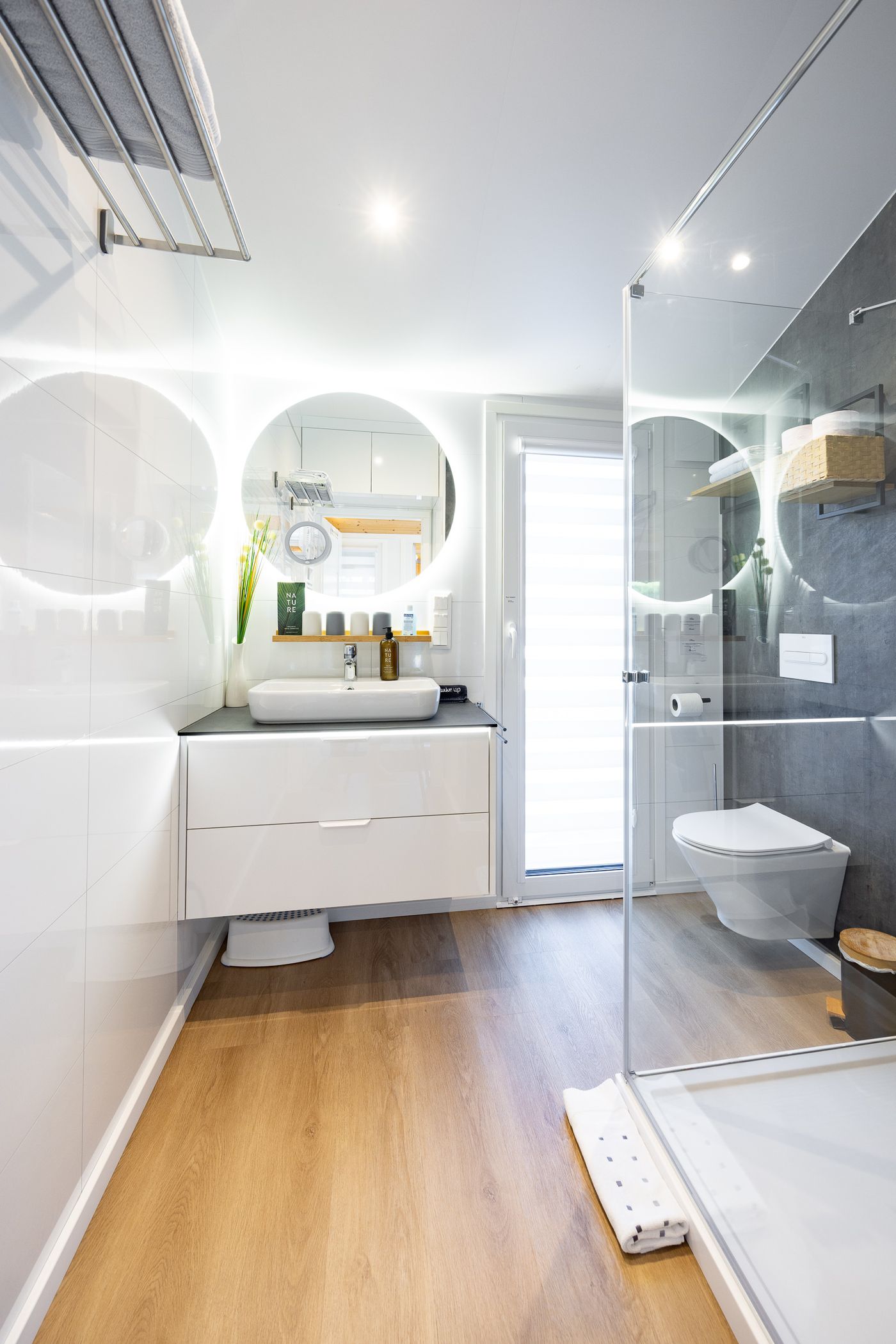 Badezimmer mit Duschkabine, Wand-WC und LED-Spiegel