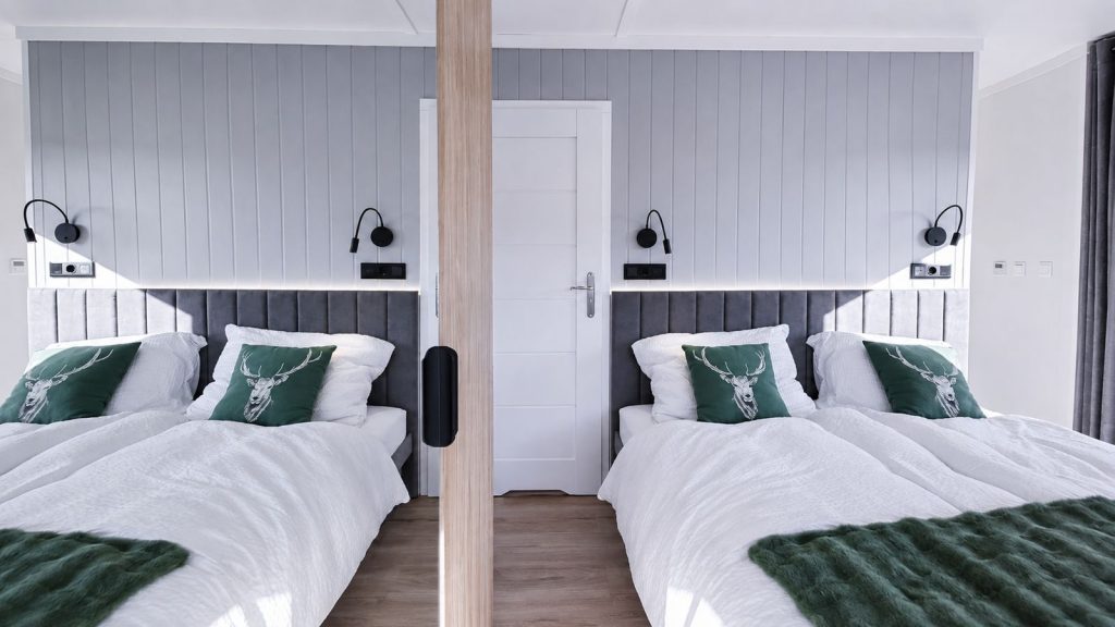 Helles Schlafzimmer mit zwei Einzelbetten und Hirsch-Kissen, vollmöbliert - Lieferung nach Graz.