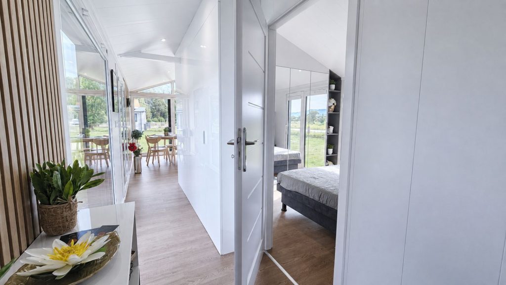 Flur im Diamond Family Deluxe mit Spiegelschrank, Essplatz und Holzakzenten - Massivmodul-Architektur, Lieferung nach Klagenfurt.