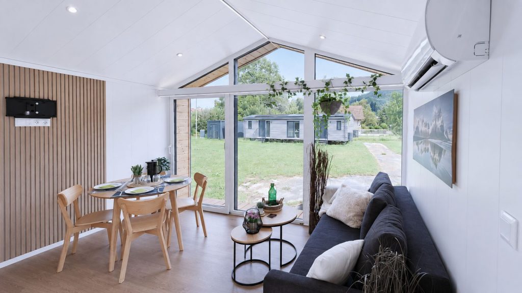 Wohn-Essbereich im Diamond Family Deluxe mit Giebelverglasung, Sofa und Essplatz - Ganzjahreshaus, Lieferung nach Kaernten.