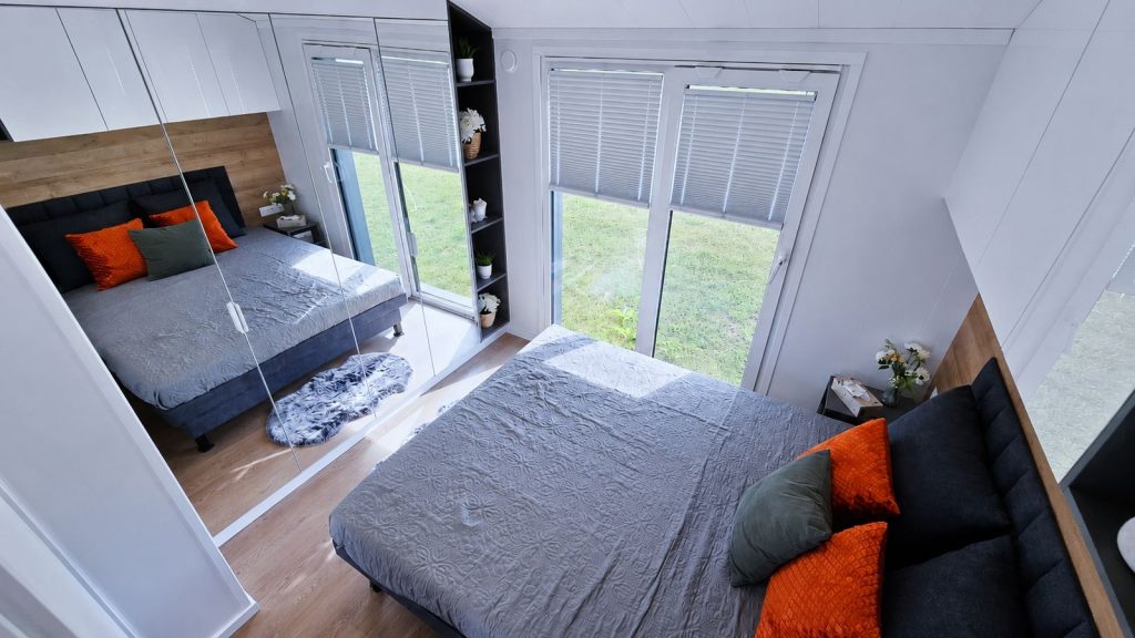 Vollmoebliertes Schlafzimmer mit Doppelbett, Spiegelschrank und Plissees an bodentiefen Fenstern, Lieferung nach St. Poelten.