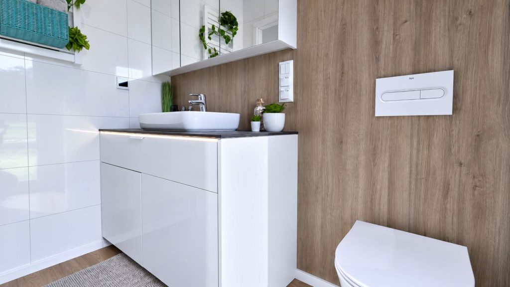 Elegantes Badezimmer mit Aufsatzwaschbecken, Holzwand und Spiegelschrank in einem BOND Fertighaus.