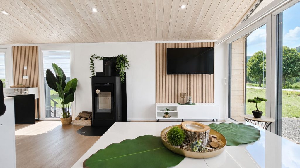 Wohnraum im Diamond +Plus mit Kaminofen, Holzdecke und bodentiefen Fenstern - Ganzjahreshaus, Lieferung nach Salzburg.
