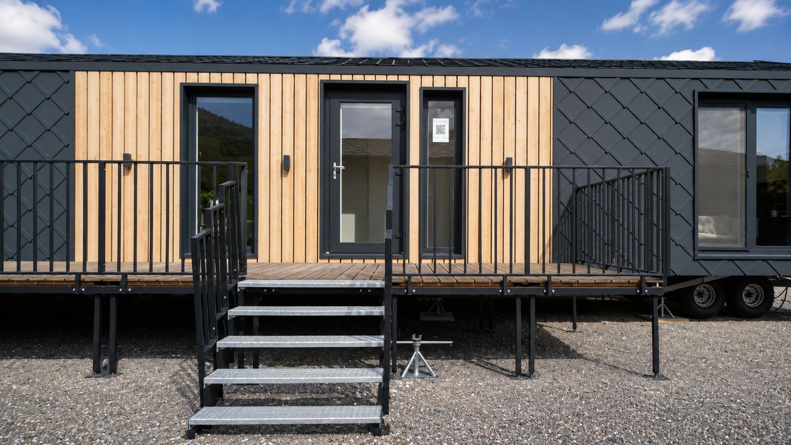 Fassadendetail des Diamond +Plus Deluxe mit Rautenblech, hellem Holz und Holzterrasse am Eingang - Modulhaus aus Oesterreich.