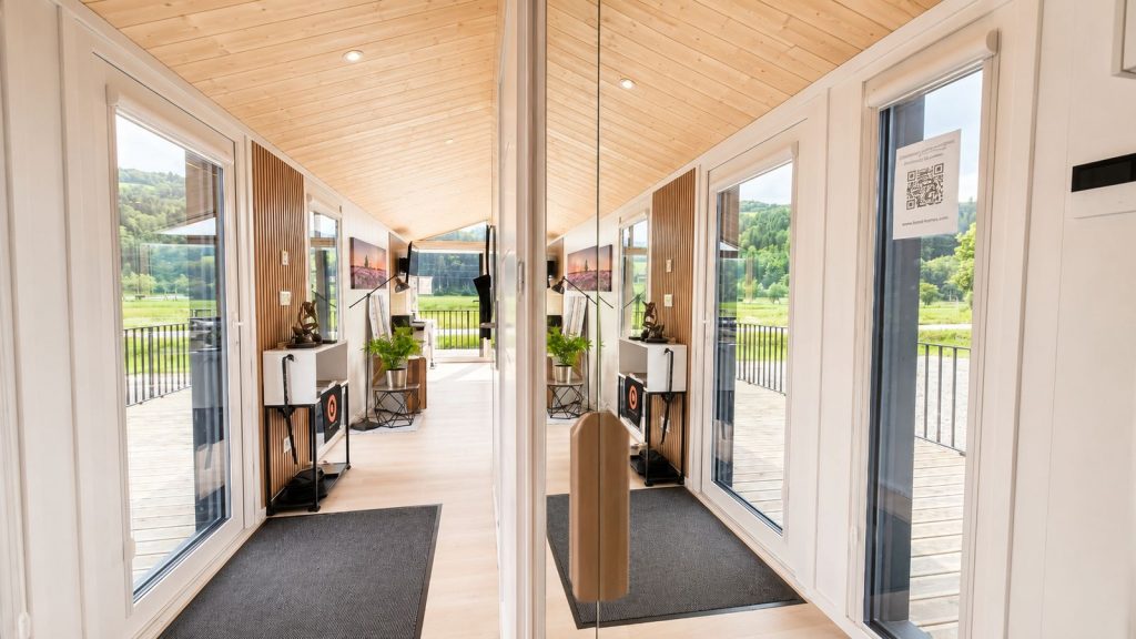 Lichtdurchfluteter Eingang mit Naturholzdecke und Panoramafenstern im Diamond +Plus Deluxe Premium-Modulhaus.