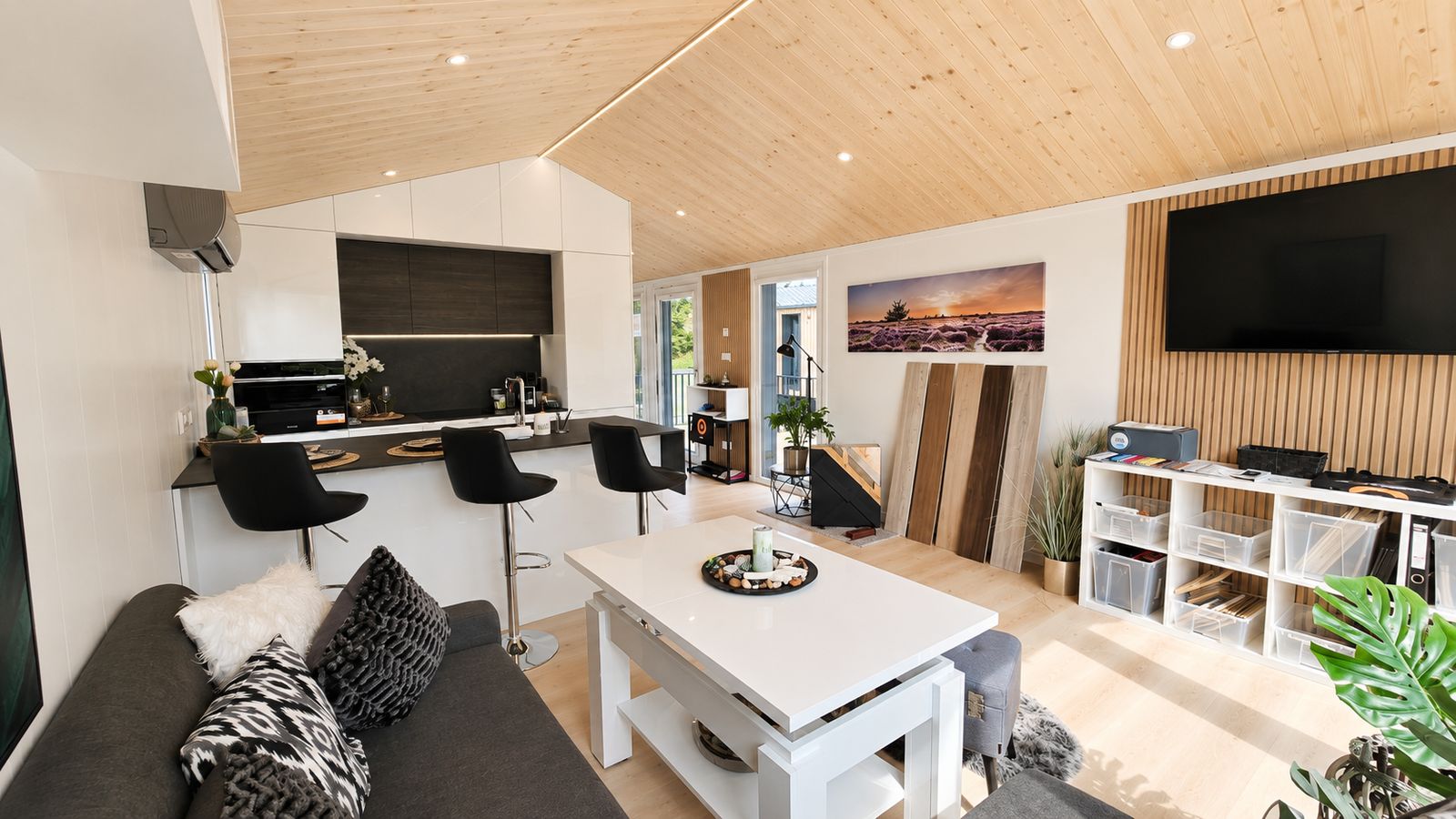 Offener Wohn- und Kuechenbereich des Diamond +Plus Deluxe mit Holzdecke und Theke, als mobiles Eigenheim verfuegbar in Linz.