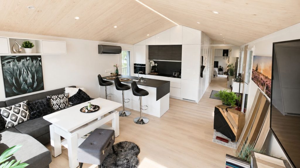 Diamond +Plus Deluxe: offener Wohnraum mit weisser Kueche und Holzdecke, modernes Eigenheim fuer Wien.