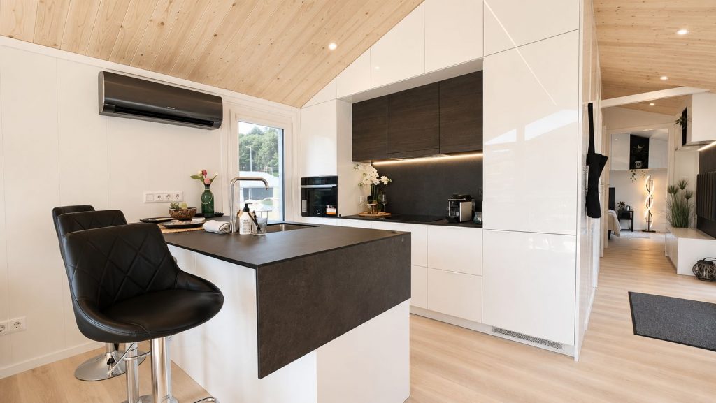 Offene Kueche mit Holzdecke, Hochglanzfronten und schwarzer Kochinsel - schluesselfertig geliefert nach Linz.