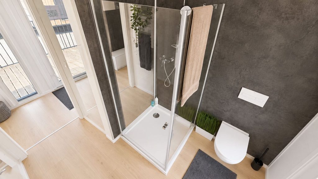 Modernes Bad im Fertigteilhaus mit Eckglasdusche, anthrazitfarbener Wand und Wand-WC von oben gesehen.