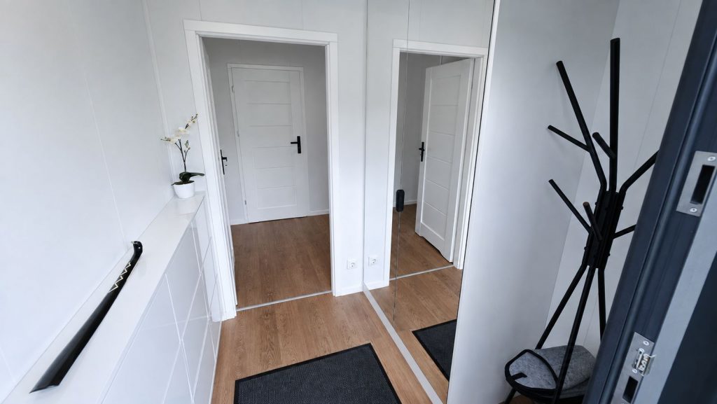 Heller Eingangsbereich mit Garderobe und Spiegel im Diamond Vario Deluxe Ganzjahreshaus, fuer Villach.