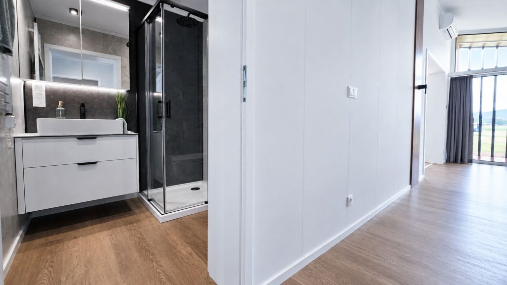 Bad und Flur im Diamond Vario Deluxe mit schwarzer Regendusche, Waschtisch und Schrankwand - vollmoebliert uebergeben.