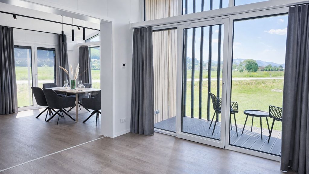 Ess- und Wohnbereich mit bodentiefen Schiebetüren zur Terrasse und Wiesenblick - Ganzjahreshaus für Krems.