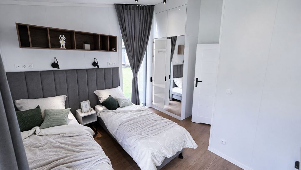 Kinderzimmer mit zwei Einzelbetten, Regalnische und Spiegelschrank - wohnfertig eingerichtet.