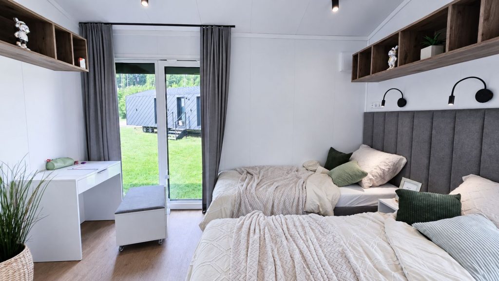 Schlafzimmer mit zwei Betten, Schreibtisch und Glastuer zur Terrasse - mobiles Eigenheim, Lieferung ins Burgenland.