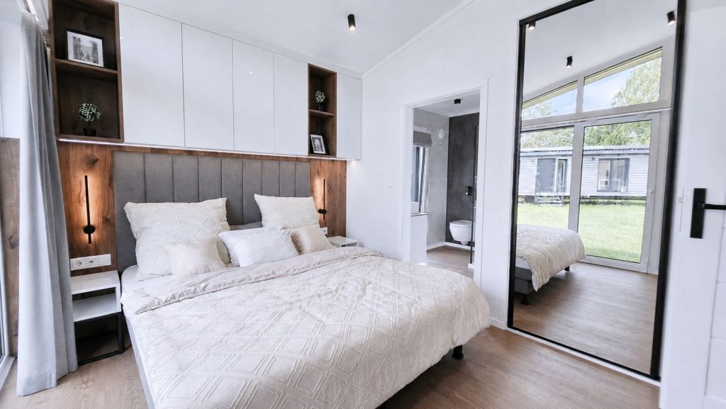 Schlafzimmer im Diamond Vario Deluxe mit Standspiegel und Durchblick zum Duschbad - wohnfertig uebergeben.