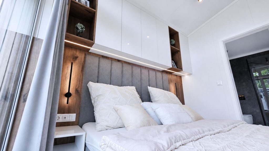 Schlafzimmer im Diamond Vario Deluxe mit gepolstertem Kopfteil, Holznische und LED-Licht, schluesselfertig - Lieferung nach Klagenfurt.