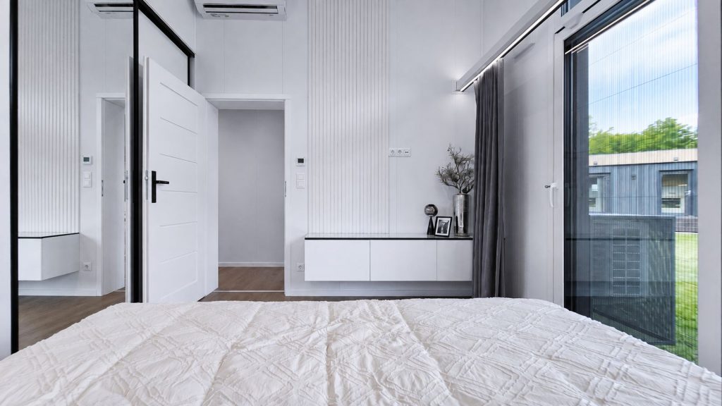 Elternschlafzimmer mit Lamellenwand, schwebendem Sideboard und Terrassentuer - modernes Eigenheim mit Lieferung nach St. Poelten.