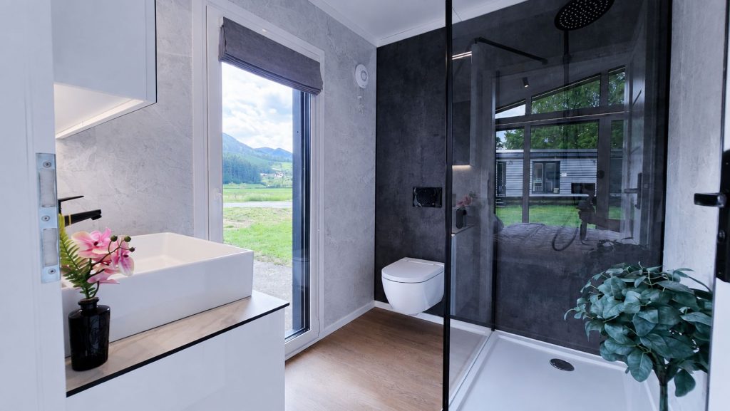 Bad mit Aufsatzbecken, schwarzer Regendusche und Marmoroptik im Diamond Vario Deluxe, Fertigteilhaus für Bregenz.