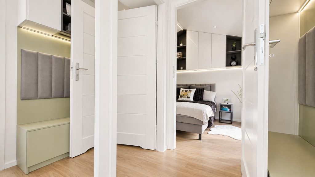 Blick durch geoeffnete Tueren ins Schlafzimmer des Diamond XS Deluxe mit Garderobenbereich - schluesselfertig, Lieferung nach Graz.
