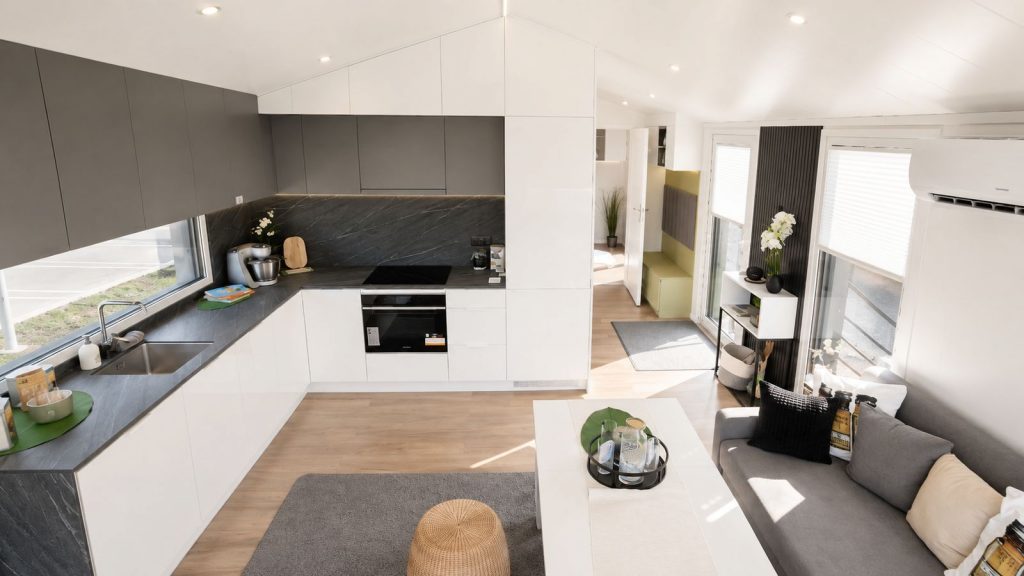 Diamond XS Deluxe mit L-Kueche in dunkler Steinoptik, Einbaubackofen und offenem Wohnbereich - wohnfertig uebergeben.