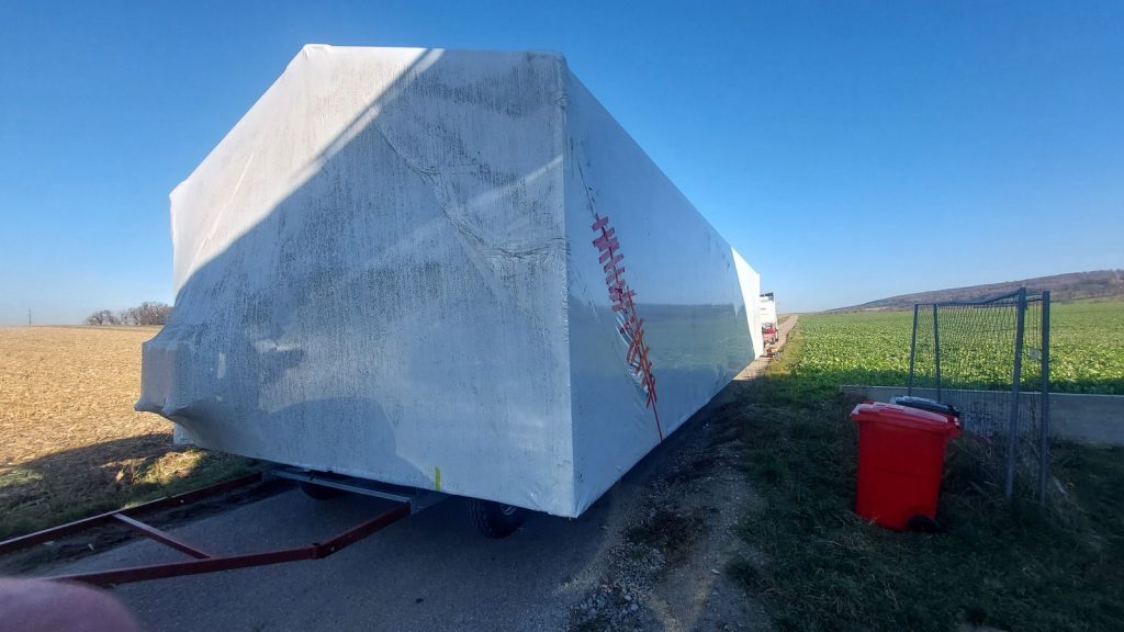 Verpacktes BOND-Modul auf dem Anhänger während der Überstellung entlang eines Feldwegs.