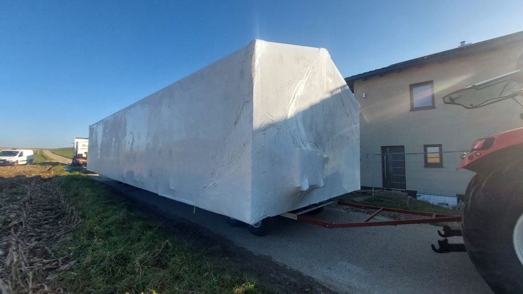 Foliertes BOND-Modul auf dem Transportgestell bei der Ankunft neben einem Wohnhaus.