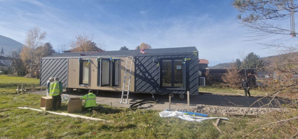 Längsseite eines Fertigteilhauses mit Rautenfassade, Holzverkleidung und Terrassentüren bei der Montage