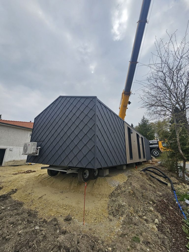 Rückwärtige Eckansicht des ATB 71 mit Rautenschindeln und Klimaeinheit auf dem Aufstellplatz.