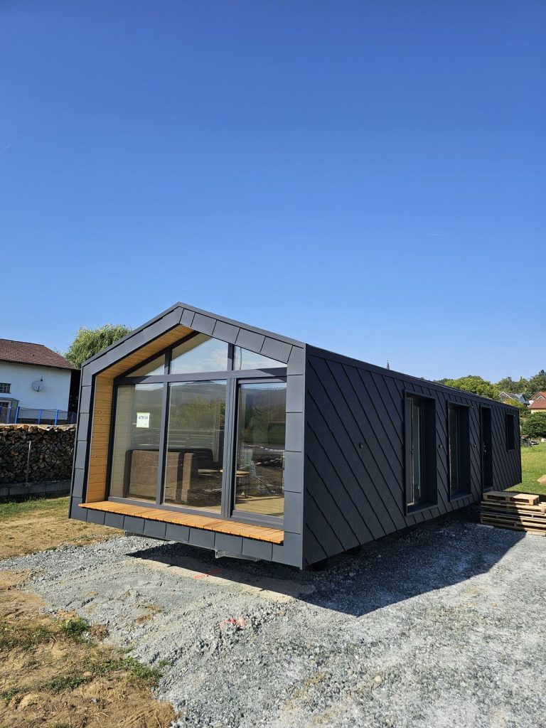 Premium-Modulhaus ATB 54 mit Panoramaverglasung und warmer Holzlaibung an der anthrazitfarbenen Rautenfassade.