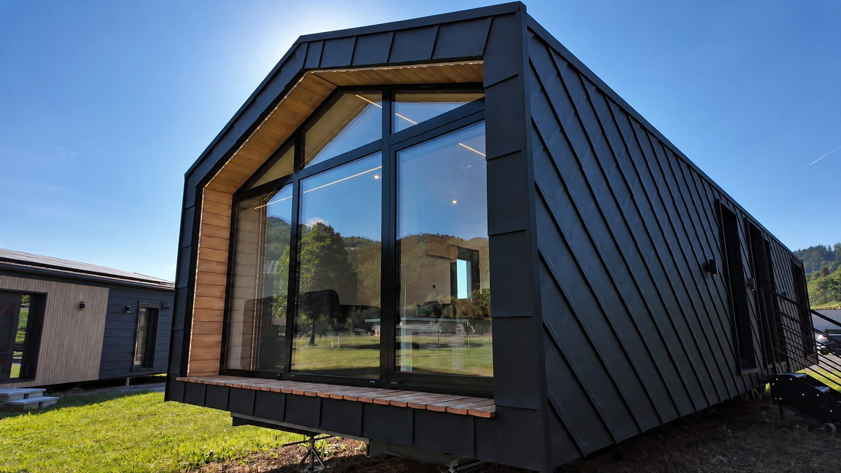 Verglaste Giebelseite des Modulhauses Diamond +Plus ATB-38 mit Terrassenschiebetüre und Aluminiumrahmen RAL 9005.