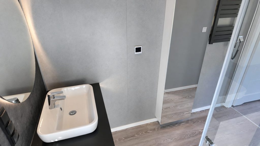 Waschbecken auf schwarzer Waschtischplatte vor grauer Wandverkleidung im Bad des Diamond +Plus ATB-38.