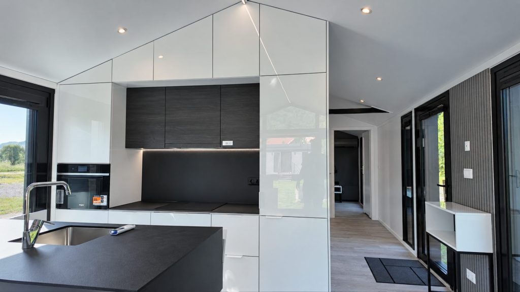 Küche des Diamond +Plus ATB-38 mit Kücheninsel, Backofen und hochglänzenden Schrankfronten.