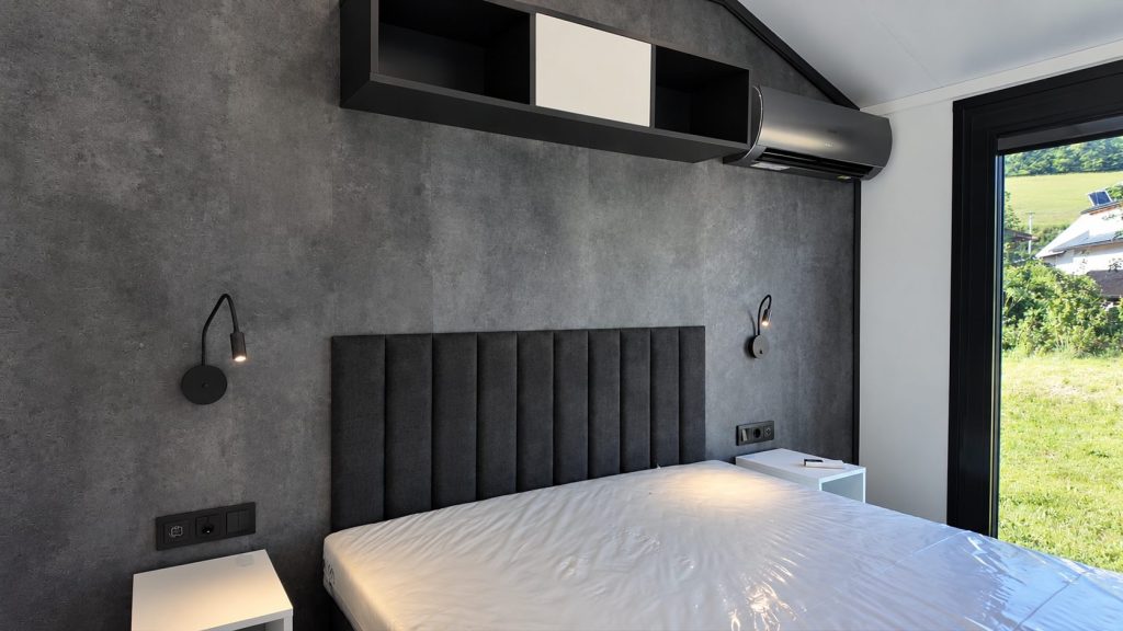 Doppelbett vor dunkler Wandfläche im Schlafzimmer des Diamond +Plus ATB-38, rechts ein Fenster.