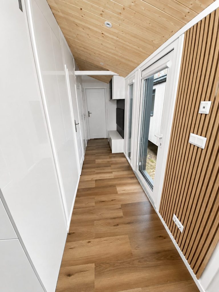 Flur des Diamond +Plus Deluxe ATB-62 mit Holzdecke, Holzlamellen und Fenstertür.