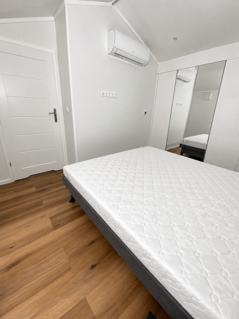 Schlafzimmer des Diamond +Plus Deluxe ATB-62 mit Doppelbett, Klimaanlage und Spiegeltür.