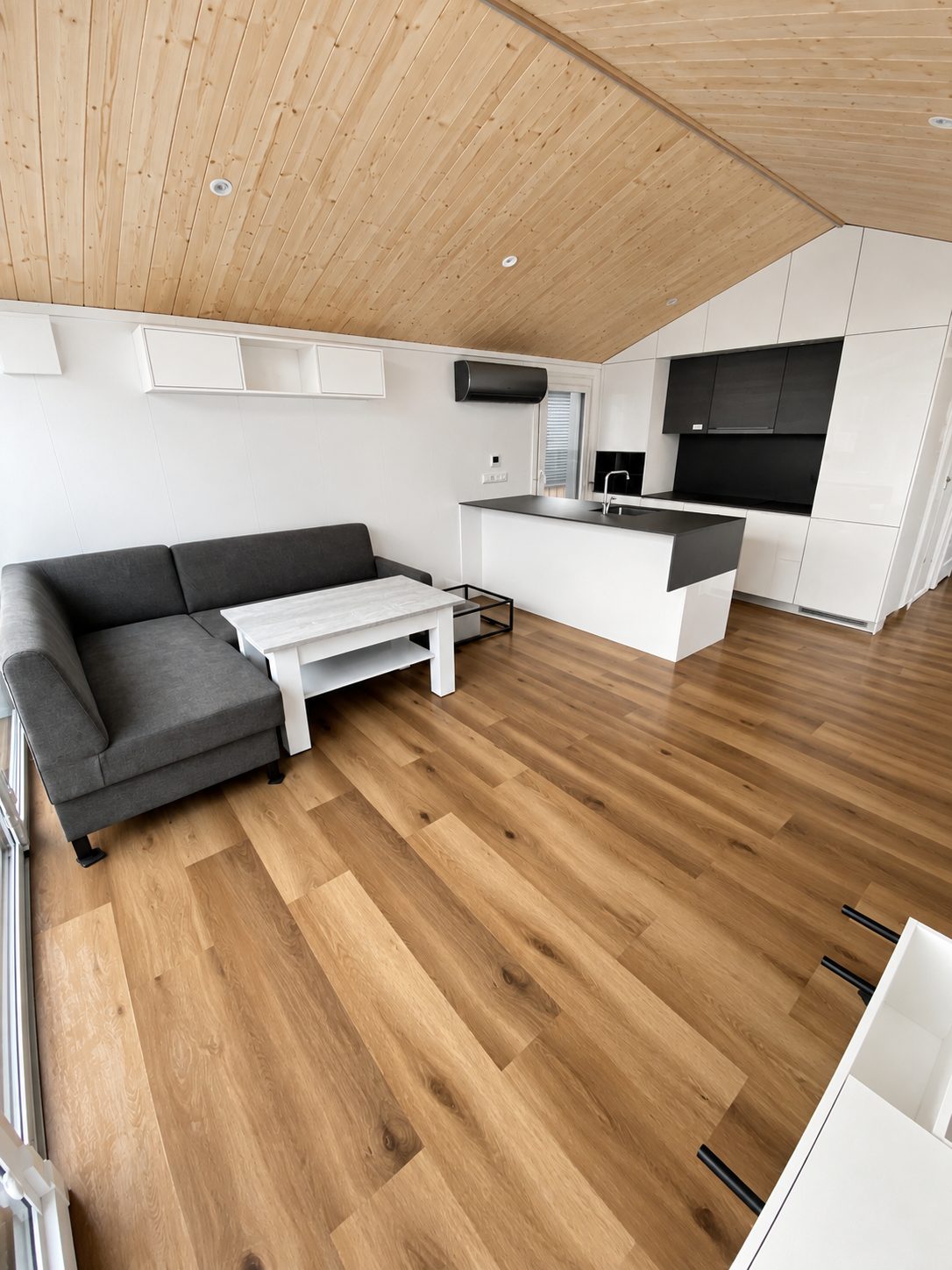 Offener Wohnbereich des Diamond +Plus Deluxe ATB-62 mit Ecksofa, Couchtisch und Küchenzeile.